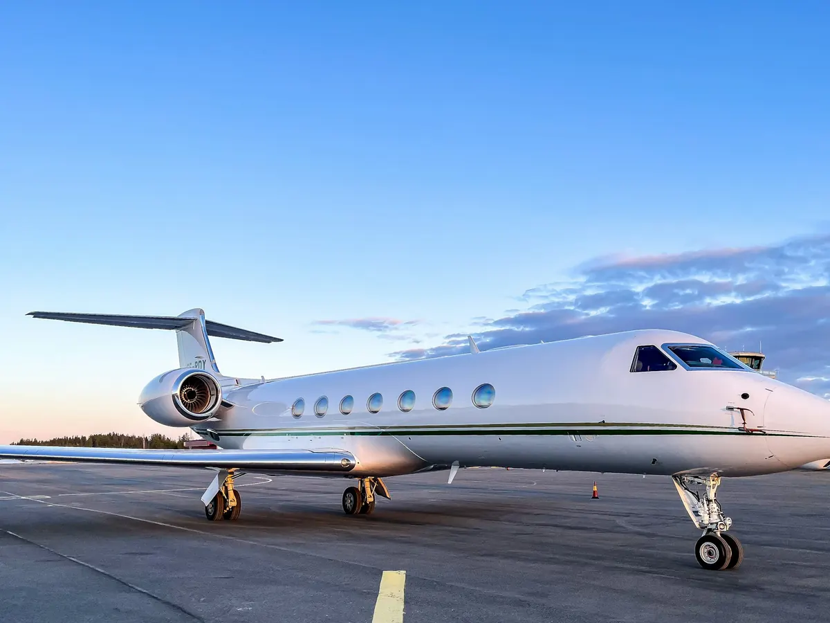 Large cabin jet parked on the ramp under a clear sky