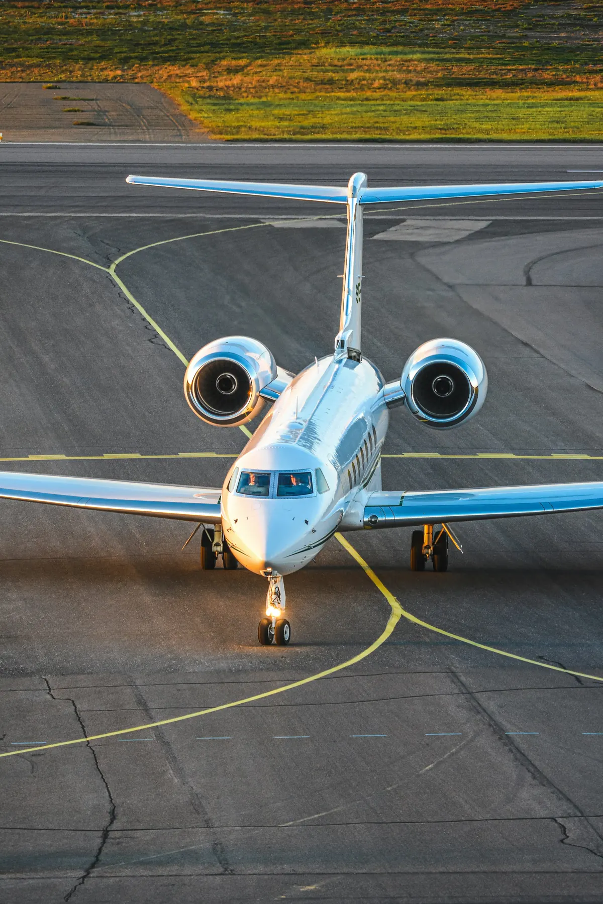 Business jet taxiing head-on along the yellow centreline